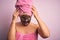 Middle age brunette woman wearing beauty black face mask over isolated pink background suffering from headache desperate and