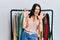 Middle age brunette woman working as professional personal shopper afraid and terrified with fear expression stop gesture with