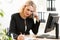 Middle-age business woman talking on the mobile phone in office. Portrait of smiling business woman.