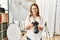 Middle age caucasian woman photographer smiling confident holding professional camera at photograph studio