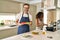 Middle age couple cooking mediterranean food at home smiling with a happy and cool smile on face