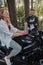 Middle age couple drinking tea, sitting on a motorcycle, traveling together on a forest road