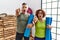 Middle age couple holding yoga mat pointing with finger surprised ahead, open mouth amazed expression, something on the front