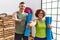 Middle age couple holding yoga mat smiling cheerful offering palm hand giving assistance and acceptance