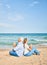 Middle age couple in love doing lotus yoga pose relaxing at the beach happy and cheerful together