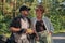 Middle age couple talking, sitting on a motorcycle, traveling together on a forest road