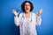 Middle age curly hair doctor woman wearing coat and stethoscope over blue background celebrating crazy and amazed for success with