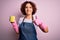 Middle age curly hair woman cleaning doing housework wearing apron and gloves using scourer happy with big smile doing ok sign,