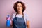 Middle age curly hair woman cleaning doing housework wearing apron and gloves using spayer scared in shock with a surprise face,