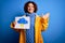 Middle age curly hair woman wearing rain coat holding banner with cloud and thunder very happy and excited, winner expression