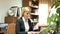 Middle age european businesswoman in business suit sitting in office at workplace and working at laptop