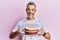 Middle age grey-haired man holding carrot cake smiling with a happy and cool smile on face