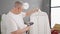 Middle age grey-haired man ironing shirt at laundry room