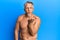 Middle age grey-haired man standing shirtless looking at the camera blowing a kiss with hand on air being lovely and sexy