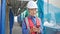 Middle age grey-haired woman builder using smartphone at street