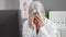 Middle age grey-haired woman doctor stressed working at clinic