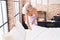 Middle age grey-haired woman smiling confident make bed at bedroom