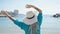 Middle age grey-haired woman tourist standing backwards dancing at beach