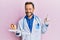 Middle age gynecologist man holding anatomical model of female uterus with fetus smiling happy pointing with hand and finger to