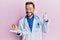 Middle age gynecologist man holding anatomical model of female uterus with fetus smiling happy and positive, thumb up doing