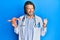 Middle age handsome gynecologist man holding anatomical model of female genital organ pointing thumb up to the side smiling happy