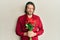 Middle age handsome man holding bouquet of red roses skeptic and nervous, frowning upset because of problem