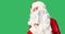 Middle age handsome man wearing Santa Claus costume and beard standing hand on mouth telling secret rumor, whispering malicious