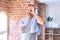 Middle age handsome sportman holding bottle of water and towel standing at gym with happy face smiling doing ok sign with hand on