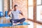 Middle age handsome sportman sitting on mat doing stretching yoga exercise at gym Pointing down with fingers showing