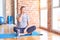 Middle age handsome sportman sitting on mat doing stretching yoga exercise at gym Yawning tired covering half face, eye and mouth