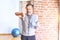 Middle age handsome sportman sweaty holding bottle of water and towel after exercise at gym with angry face, negative sign showing