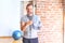 Middle age handsome sportman sweaty holding bottle of water and towel after exercise at gym very happy pointing with hand and