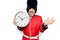 Middle age handsome wales guard man wearing traditional uniform holding big clock celebrating achievement with happy smile and