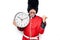 Middle age handsome wales guard man wearing traditional uniform holding big clock pointing thumb up to the side smiling happy with