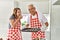 Middle age hispanic couple smiling happy baking cookies at the kitchen