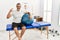 Middle age hispanic man at pain recovery clinic holding pilates ball smiling and confident gesturing with hand doing small size