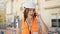 Middle age hispanic woman builder talking on smartphone at construction place