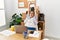 Middle age hispanic woman business woman stretching back at work at business office