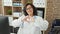 Middle age hispanic woman doctor smiling doing heart gesture with hands at the clinic