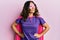 Middle age hispanic woman dressing as superhero wearing pink and purple feminist colors, smiling with confidence