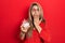 Middle age hispanic woman holding bowl with sugar covering mouth with hand, shocked and afraid for mistake