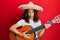 Middle age hispanic woman holding mexican hat playing classical guitar depressed and worry for distress, crying angry and afraid