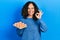 Middle age hispanic woman holding tray of fresh eggs doing ok sign with fingers, smiling friendly gesturing excellent symbol
