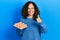 Middle age hispanic woman holding tray of fresh eggs smiling happy and positive, thumb up doing excellent and approval sign