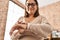 Middle age hispanic woman looking smartwatch standing at home