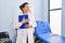 Middle age hispanic woman physiotherapist holding clipboard at rehab clinic