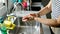 Middle age hispanic woman washing hands at the kitchen