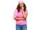 Middle age hispanic woman wearing breast cancer support pink scarf serious face thinking about question with hand on chin,