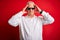 Middle age hoary man wearing funny sunglasses over isolated red background suffering from headache desperate and stressed because