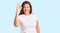 Middle age latin woman wearing casual white tshirt smiling positive doing ok sign with hand and fingers